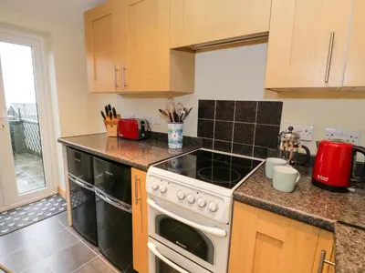 a kitchen with a stove top oven next to a window at Edrydd in Harlech