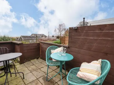 a patio with two chairs and a table on a balcony at Edrydd in Harlech