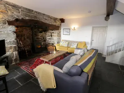 a living room with a couch and a fireplace at Goronwy Cottage in Barmouth