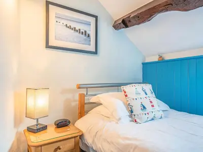 a bedroom with a bed and a table with a lamp at Goronwy Cottage in Barmouth