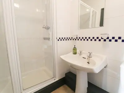 a bathroom with a sink and a shower at Goronwy Cottage in Barmouth