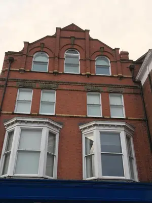 a tall brick building with white windows at Flat G, 8 Castle Street in Ludlow