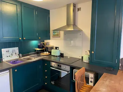 a kitchen with blue cabinets and a stove top oven at Flat G, 8 Castle Street in Ludlow