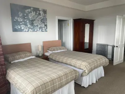 a room with two beds and a painting on the wall at Highland Moors in Llandrindod Wells