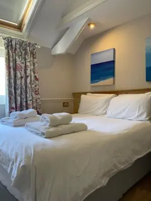 a bedroom with a white bed with towels on it at Tynycornel Hotel in Tal-y-llyn