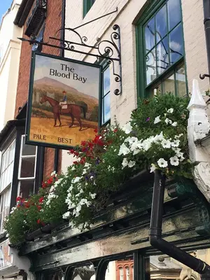 a sign on the side of a building with flowers at Beautiful stylish 2 bed apartment with free parking in Ludlow