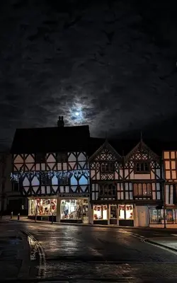 a building at night with the moon in the sky at Beautiful stylish 2 bed apartment with free parking in Ludlow