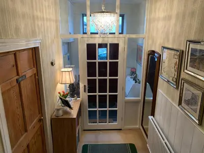 a hallway with a door and a chandelier at Evangelisa in Lampeter
