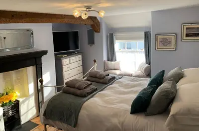 a bedroom with a bed with pillows and a fireplace at Evangelisa in Lampeter