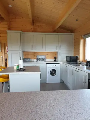 a kitchen with white cabinets and a washer and dryer at Ruth's Retreat Beautiful Country Retreat with private hot tub & wonderful views in Shrewsbury