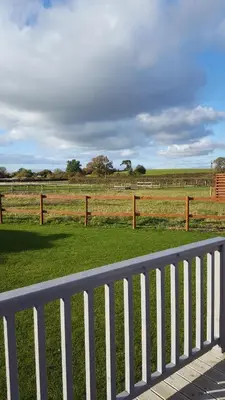 a white fence in front of a field of grass at Ruth's Retreat Beautiful Country Retreat with private hot tub & wonderful views in Shrewsbury