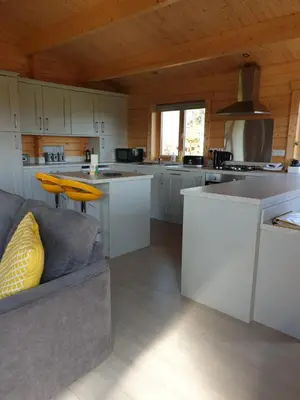 a kitchen with white cabinets and a couch in a room at Ruth's Retreat Beautiful Country Retreat with private hot tub & wonderful views in Shrewsbury