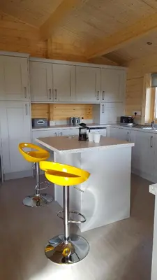 a kitchen with two yellow bar stools and a counter at Ruth's Retreat Beautiful Country Retreat with private hot tub & wonderful views in Shrewsbury