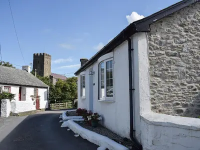 a stone house with snow on the side of a street at Glasfor in Llanon