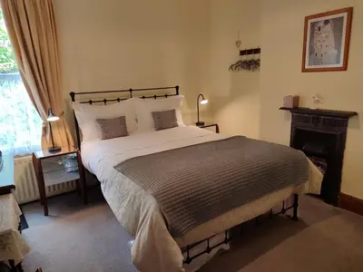a bedroom with a large bed and a fireplace at Anton Guest House Bed and Breakfast in Shrewsbury