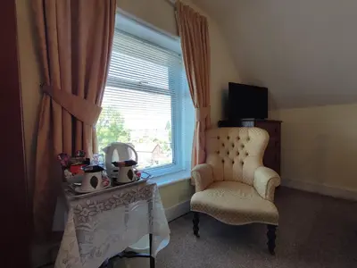 a living room with a chair and a window at Anton Guest House Bed and Breakfast in Shrewsbury