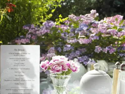 a vase filled with pink flowers next to a sign at Anton Guest House Bed and Breakfast in Shrewsbury