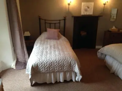 a bedroom with a bed with white sheets and pink pillows at The Poppy House in Bishops Castle