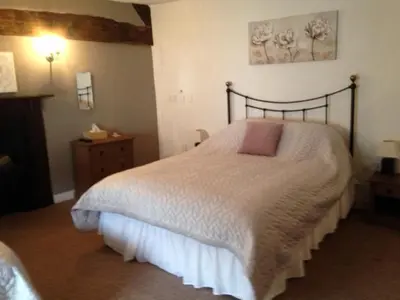 a bedroom with a bed with a white comforter at The Poppy House in Bishops Castle