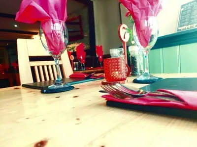 a wooden table with two wine glasses on it at The Black Lion Royal Hotel in Lampeter