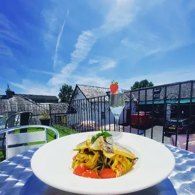 a plate of food on a table with a drink at The Black Lion Royal Hotel in Lampeter