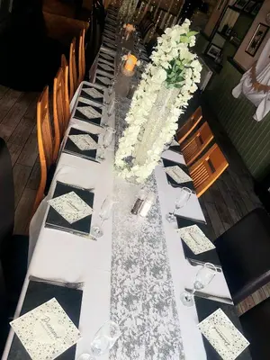 a long table with black and white plates and glasses at The Black Lion Royal Hotel in Lampeter