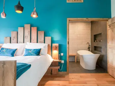 a bedroom with a large bed and a bathtub and a tub at The Pendre Longbarn in Pentre-briwnant
