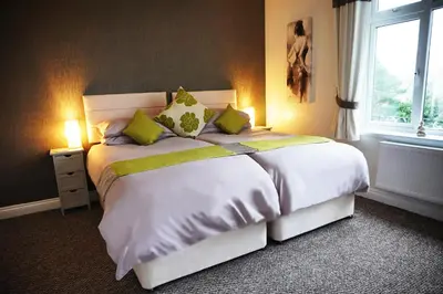 a bedroom with a large white bed with green pillows at Borthwenbnb in Dolgellau