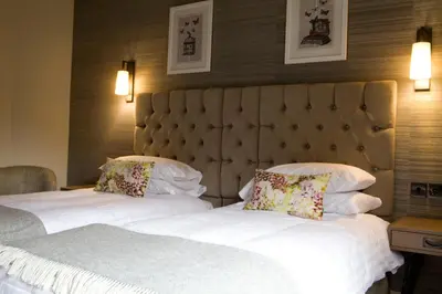 two beds in a hotel room with two pillows at Royal Ship in Dolgellau