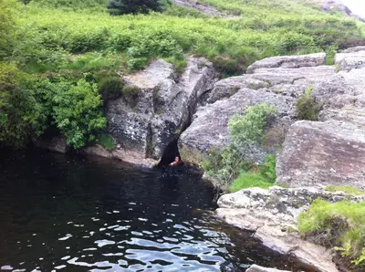 a person is standing in the water near some rocks at Ardwyn House in Llanwrtyd Wells