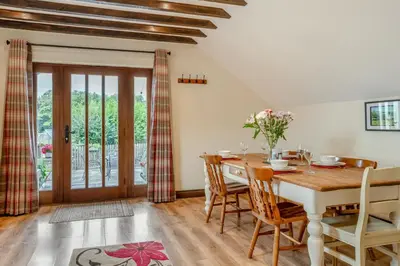 a dining room with a wooden table and chairs at 2 Bed in Trallong oc-bow106 in Sennybridge