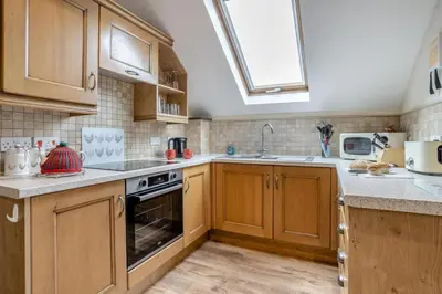 a kitchen with wooden cabinets and a sink and a stove at 2 Bed in Trallong oc-bow106 in Sennybridge