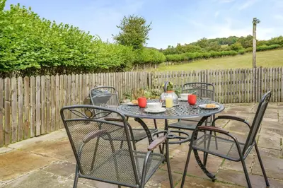 a patio table with four chairs and a fence at 2 Bed in Trallong oc-bow106 in Sennybridge