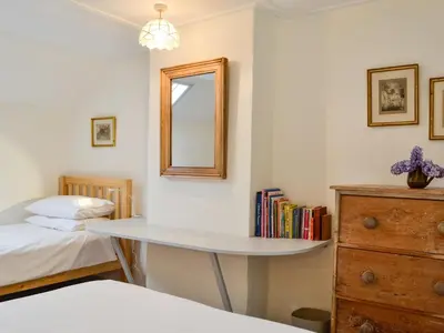 a bedroom with a desk with a mirror and a bed at Bridge End Cottage in Cregrina