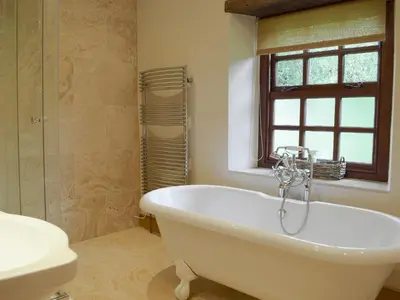 a bathroom with a tub and a toilet and a sink at The Oak in Newchurch