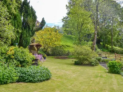 a garden with a bench and a gazebo at The Oak in Newchurch