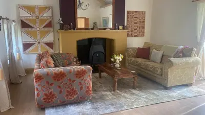 a living room with two couches and a fireplace at The Rose Barn, Ysgubor y Rhosyn in Llandysul