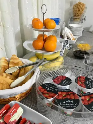 a table topped with plates of food and fruit at Helmsman Guesthouse in Aberystwyth