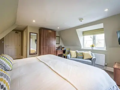 a bedroom with a large white bed and a couch at The Cliffe at Dinham in Ludlow