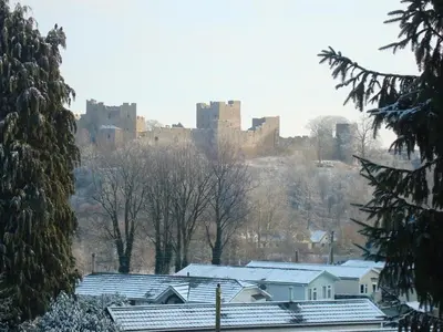 a city with a castle on a hill with snow covered roofs at The Cliffe at Dinham in Ludlow