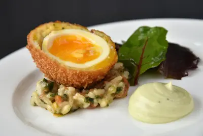 a white plate with an egg on top of food at The Cliffe at Dinham in Ludlow