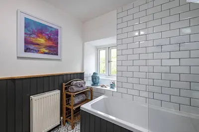 a bathroom with a white tub and a window at Hawddamor in Dolgellau