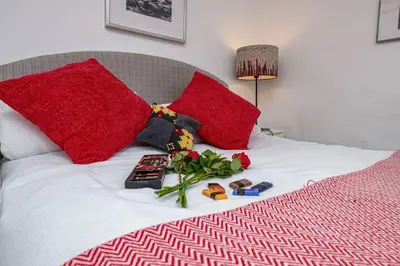 a bed with red pillows and toys on it at Hawddamor in Dolgellau