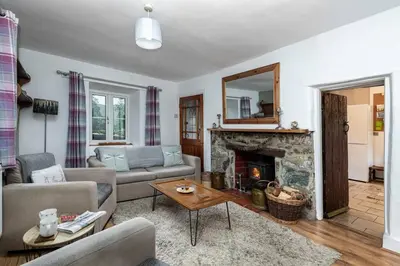 a living room with a couch and a fireplace at Hawddamor in Dolgellau