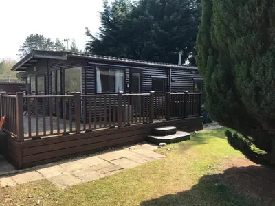 a wooden cabin with a porch and a yard at Sherdale lodge in Builth Wells