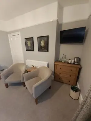 a living room with two chairs and a television at LLys Aeron 