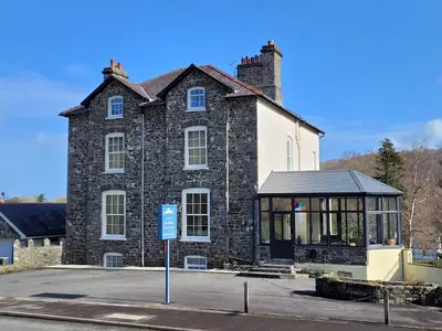 a large brick building with a gazebo in front of it at LLys Aeron 