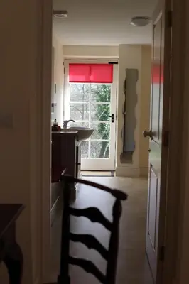 a kitchen with a window and a chair in a room at Glanhenwye Courtyard Cottages in Glasbury