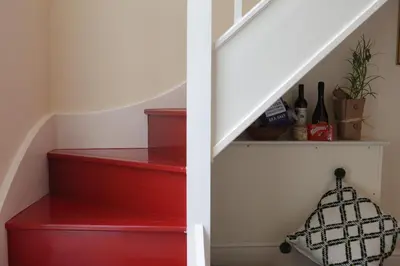 a stairway with red steps and a white stair case at Glanhenwye Courtyard Cottages in Glasbury