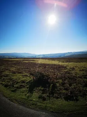 a view of a field with the sun in the sky at Pen-Rhos luxury glamping 